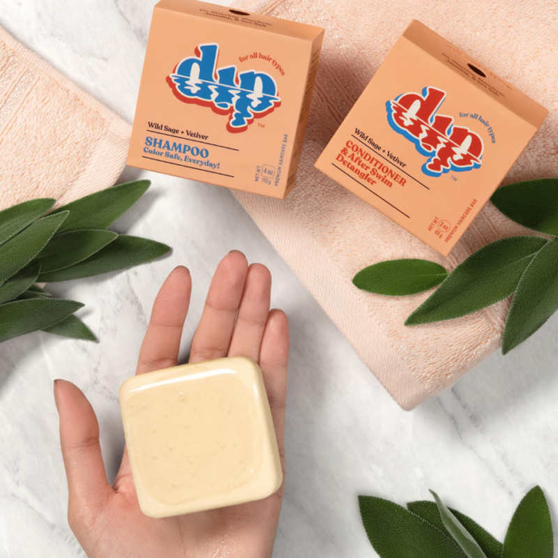 a white, square shampoo bar held in a person's palm