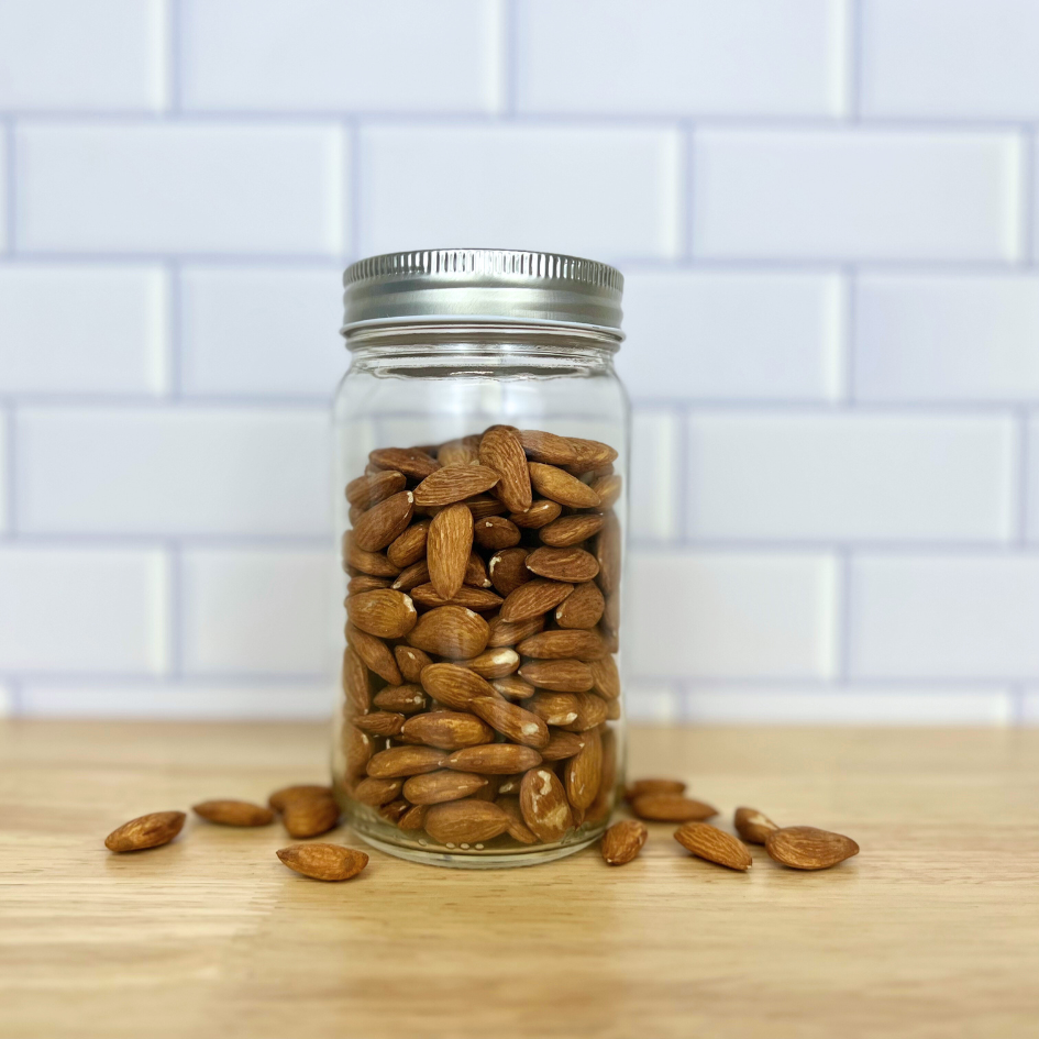 Raw almonds in a clear glass mason jar
