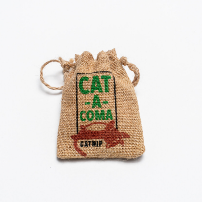 Purr Say burlap catnip toy. Designed with a cat laying on its back and the phrase "Cat-A-Coma" in green text.